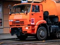 Orange irrigation sweepers truck stand on the tram tracks. Moscow coat of arms. Cityscape
