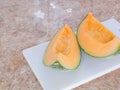 Orange japanese melon on a white block in kitchen