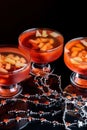 Orange jello on a beautiful bowl with fruit pieces inside. Black background.