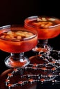 Orange jello on a beautiful bowl with fruit pieces inside. Black background.