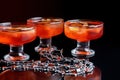 Orange jello on a beautiful bowl with fruit pieces inside. Black background, three vases with jelly. Side view.