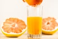 Orange juice being squeezed into a glass.