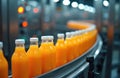 Orange juice bottles move along conveyor belt in modern food production facility. Automated system transports liquid beverages Royalty Free Stock Photo