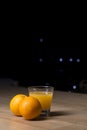 Orange juice on a drinking glass with fresh oranges fruit on a wooden table Royalty Free Stock Photo