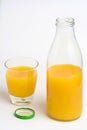 Orange juice, glass and bottle uncovered