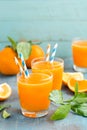 Orange juice in glass and fresh fruits with leaves on wooden background Royalty Free Stock Photo