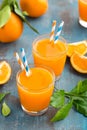 Orange juice in glass and fresh fruits with leaves on wooden background Royalty Free Stock Photo