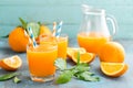 Orange juice in glass and fresh fruits with leaves on wooden background Royalty Free Stock Photo