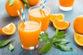 Orange juice in glass and fresh fruits with leaves on wooden background Royalty Free Stock Photo