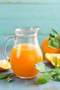 Orange juice in glass and fresh fruits with leaves on wooden background Royalty Free Stock Photo