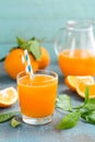 Orange juice in glass and fresh fruits with leaves on wooden background Royalty Free Stock Photo