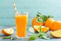 Orange juice in glass and fresh fruits with leaves on wooden background Royalty Free Stock Photo