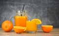 Orange juice in the glass jar and fresh orange fruit slice on wooden table - Still life glass juice on dark Royalty Free Stock Photo