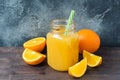 Orange juice in glass jar and fresh fruits oranges on dark background with copy space Royalty Free Stock Photo