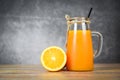 Orange juice in the glass jar and fresh orange fruit slice on wooden table - Still life glass juice on dark background Royalty Free Stock Photo