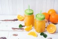 Orange juice in glass jars and fresh oranges on a white wooden rustic background Royalty Free Stock Photo