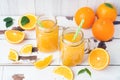 Orange juice in glass jars and fresh oranges on a white wooden rustic background Royalty Free Stock Photo