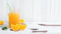 Orange juice in glass jars and fresh oranges on a white wooden rustic background Royalty Free Stock Photo