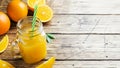 Orange juice in glass jars and fresh oranges on a wooden rustic background. Copy space Royalty Free Stock Photo