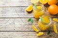 Orange juice in glass jars and fresh oranges on a wooden rustic background. Copy space Royalty Free Stock Photo