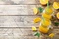 Orange juice in glass jars and fresh oranges on a wooden rustic background. Copy space Royalty Free Stock Photo