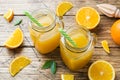 Orange juice in glass jars and fresh oranges on a wooden rustic background Royalty Free Stock Photo