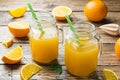 Orange juice in glass jars and fresh oranges on a wooden rustic background Royalty Free Stock Photo