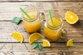 Orange juice in glass jars and fresh oranges on a wooden rustic background Royalty Free Stock Photo