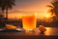 Orange juice in a glass on a wooden table on a background of palm trees Royalty Free Stock Photo