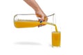 Orange juice isolate. A woman pours orange juice into a glass. Juice filling process on white background, isolated space Royalty Free Stock Photo