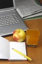 Orange juice,laptop,apple,notepad and pen