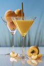 Orange juice in a martini glass with a straw surrounded by an open apricot and apricot slices Royalty Free Stock Photo