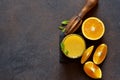 Orange juice, oranges and and juicer on stone background. Top view with copy space