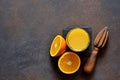 Orange juice, oranges and and juicer on stone background. Top view with copy space Royalty Free Stock Photo