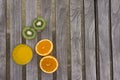 Orange juice, oranges and kiwis on a table