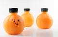 Orange juice in a plastic spherical bottles with emotional face