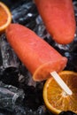 Orange juice popsicles over ice Royalty Free Stock Photo