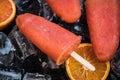 Orange juice popsicles over ice Royalty Free Stock Photo