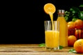 orange juice pouring into glass on dark background. fresh organic orange juice Royalty Free Stock Photo