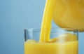 Orange juice pouring from jug into glass Royalty Free Stock Photo