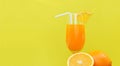 Orange juice summer glass with piece orange fruit with yellow background