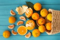 Orange juicy tangerine slices and peeled mandarines scattered on the wooden turquoise background. Flat lay. Copy space. Fresh Royalty Free Stock Photo
