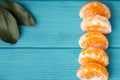 Orange juicy tangerine slices on the wooden turquoise background. Flat lay. Copy space. Fresh summer vitamin rich fruits Royalty Free Stock Photo