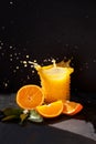 Orange juice splash in the bright sun with black background, beautiful sunny day