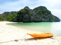 Orange kayak boat on white sand beach