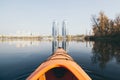 Orange kayak sailing towards modern buildings on the waters of Dnipro river in Kyiv, Ukraine Royalty Free Stock Photo