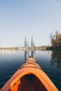 Red kayak sailing towards modern buildings on the waters of Dnipro river in Kyiv, Ukraine