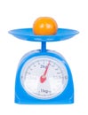 Orange on kitchen scale isolated on white background Royalty Free Stock Photo