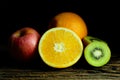 Orange, kiwi and apple on wood plate with moody and dark style Royalty Free Stock Photo