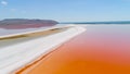 Orange lake in Crimea. Shot. Top view of bright orange lake water against white sand. Extraterrestrial landscape of